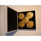 En åben æske viser fem skinnende guldfarvede mønter arrangeret indeni på en sort baggrund.