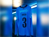 Lyseblå langærmet trøje med GREENTEL, HØEGH og tallet 3 på ryggen.