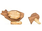 To minimalistiske dyrefigurer i træ, den ene ligner en kylling med lagdelte dele, og den anden ligner en kylling, begge fremstillet af forskellige nuancer af træ.