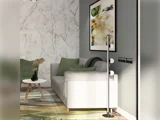 En moderne stue med en hvid sofa, grønne puder, et rundt sofabord, et abstrakt tæppe, en gulvlampe, vægkunst og en accentvæg i marmor.
