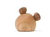 En lille, rund træfigur med to mørkere ørelignende træformer på toppen, der ligner et bjørnehoved, på en hvid baggrund.