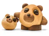 To runde pandabjørnefigurer i træ med enkle, mørke øjne og ører; den ene er større og har en arm om den mindre, begge på en hvid baggrund.