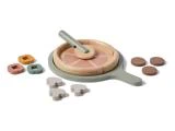 Et legetøjspizzasæt i træ med seks stykker, der kan skæres i skiver, en grøn pande, en spatel og forskellige toppings, bl.a. svampe, cirkler og blomsterformer.