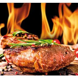 Grillet bøf garneret med krydderurter og peberkorn, mens flammerne stiger i baggrunden.
