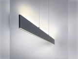 En moderne, rektangulær sort pendel hænger ned fra loftet i to tynde kabler og oplyser en almindelig, lysegrå væg.