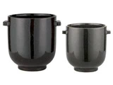 To blanke sorte keramikpotter med små håndtag i siden, en større og en mindre, udstillet mod en hvid baggrund.
