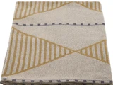 Et foldet beige tekstil med geometriske mønstre i sennepsgul og blå, med striber og trekantede former.