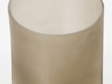 Nærbillede af en gennemskinnelig, beige cylinderformet genstand med en glat overflade, muligvis en glas- eller plastbeholder, på en hvid baggrund.