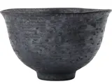 En mørkegrå keramikskål med en meleret, struktureret overflade og en let udsvajet kant på en hvid baggrund.