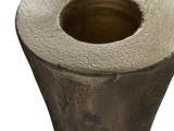 Nærbillede af den øverste kant og åbningen af en grov tekstureret, cylindrisk metalgenstand med en hul midte.