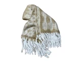 Et beige og hvidt tæppe med tie-dye-mønster og lange, tykke hvide frynser på den ene kant på en hvid baggrund.