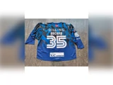 En blå og sort ishockeyskjorte med nummeret 35 og teksten »DILLING FECERS« på ryggen samt forskellige sponsorlogoer.
