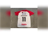 Bagside af en hvid og rød sportstrøje med navnet ANDERSSON og nummer 11 trykt på ryggen samt forskellige sponsorlogoer.