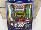 Legetøjsbilsæt til børn fra 3 år, indeholder en gul skolebus, en rød bil, træer, trafikskilte, kegler og dæk, pakket i en æske mærket Little Explorer City Car Set.