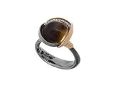 En tofarvet ring med en mørk, rund ædelsten indfattet i en guldramme, accentueret af små hvide sten, og et sort bånd med indgraverede detaljer.