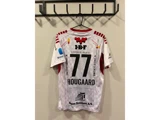 En hvid sportstrøje med røde detaljer hænger på en krog og bærer nummeret 77 og navnet HOUGAARD samt forskellige sponsorlogoer.
