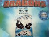 Et blåt Dragons-sengesæt med legende tegneseriedrager, tekst i 100 % bomuld til højre og lyneffekter i baggrunden.