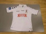 En hvid fodboldtrøje med sorte og røde detaljer, der viser CERES i et rødt banner, sponsorlogoer og AGF Aarhus' fodboldklubs våbenskjold på brystet.