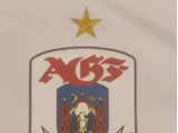En hvid baggrund med et våbenskjold med AGS i røde bogstaver, et emblem med to røde tårne, figurer, en halvmåne og en stjerne, toppet af en enkelt guldstjerne.