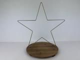 En stjerneformet ramme af guldmetal er fastgjort til en rund træbase på en almindelig hvid baggrund.