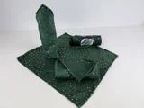 Grønne stofservietter med et guldstjernemønster vises: en udrullet, to rullede og en i en indpakning, alt sammen på en hvid overflade.