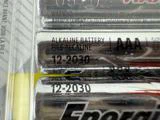 Nærbillede af alkaliske AAA-batterier i emballage, der viser etiketten ALKALINE BATTERY og udløbsdatoen 12-2030, der er trykt på batterierne.