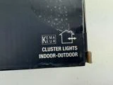 Nærbillede af en sort produktboks med teksten KEMA KEUR Cluster Lights Indoor-Outdoor og et simpelt husomrids-ikon.