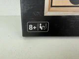 Et spil i en æske med et symbol, der viser, at det er egnet fra 8 år og opefter, og et andet symbol, der viser en eller flere spillere.