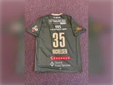 En grå sportstrøje med nummeret 35 og navnet NICKELSEN på ryggen, med forskellige sponsorlogoer og hvid tekst.