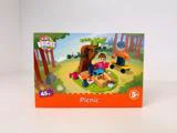 Kids Bricks-legetøjskasse mærket Picnic med to figurer, et træ, picnic-mad og et skateboard i en parkscene; fra 5 år, 45 dele.