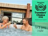 En ældre kvinde og en midaldrende mand skåler med champagne i et udendørs boblebad. Teksten lyder Travelers Choice 2025 og For 3. gang i træk! på højre side.