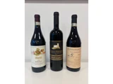 Tre flasker italiensk rødvin står oprejst side om side på en hvid baggrund: Vietti Barolo, Castello di Monsanto Chianti Classico og Barbaresco.