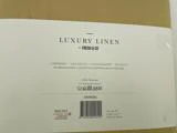 Etiket til luksus sengetøjssæt i hør fra Fresh & Co i okker. Detaljer omfatter størrelse, materiale (100 % polyester), plejesymboler og OEKO-TEX STANDARD 100-certificering.