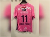 Lyserød og sort sportstrøje med nummeret 11, navnet AABERG IVERSEN og forskellige sponsorlogoer trykt på ryggen.