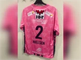 Lyserød trøje med nummer 2 og navnet NIELSEN på ryggen, med flere sponsorlogoer og tekster, herunder IBF og DET FAGLIGE HUS.
