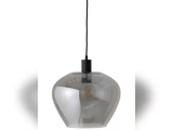 En moderne pendel med en røggrå glasskærm, sort ledning og en pære med synlig glødetråd, ophængt foran en hvid baggrund.