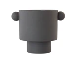 En moderne, mat sort, cylindrisk vase med to runde fremspring på modsatte sider, der ligner ører, og en tyk fod, set på en hvid baggrund.
