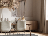 En moderne spisestue med træbord, lysegrå stole, lysekrone med tørrede blomster, abstrakt vægkunst og indretning i neutrale toner.