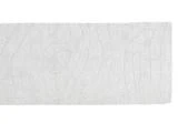 Et rektangulært hvidt tæppe med et subtilt, hævet mønster, der ligner trækorn.