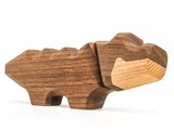 Udskåret dinosaurlegetøj i træ med geometrisk design, fremstillet af mørkt og lyst træ, stående på fire ben mod en hvid baggrund.