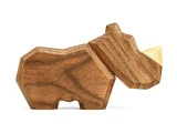 En minimalistisk næsehornsfigur i træ med et geometrisk design og et horn i en lysere farve på en hvid baggrund.