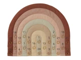 En regnbueformet stofkalender med 24 nummererede lommer, der hver indeholder en lille træring, i nuancer af brunt, beige og lyserødt.