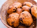 En flettet kurv fyldt med adskillige gyldenbrune kager med chokoladestykker og havregryn, hvoraf nogle har synlige chokoladestykker.