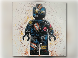 Graffiti-lignende maleri af en LEGO minifigur-silhuet, dækket af farverige tags og klatter, med ordet BRICK skrevet flere steder.