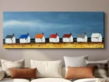 Et maleri over en sofa viser syv hvide huse med tag i forskellige farver, der står mod en blå himmel og en gul mark.