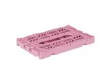 En lyserød, rektangulær foldekasse i plast vises i sammenfoldet, flad position med dekorative udskæringer på overfladen.