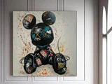 Et farverigt graffiti-maleri af en Mickey Mouse-figur med forskellige tags og stænk, der hænger på en hvid panelvæg nær et vindue.