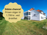 En hvid hotelbygning med rødt tag på en solskinsdag, grøn græsplæne foran. Tekstboblen siger: Sidste chance! Prisen stiger til 1.799 kr. ved årsskiftet.