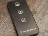 En sort fjernbetjening mærket nordic flame med tre knapper mærket med ikoner, inklusive en fremtrædende OFF-knap i midten.