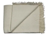 Et cremefarvet vævet tæppe med frynsede kanter, pænt foldet med det ene hjørne vendt om for at vise strukturen.